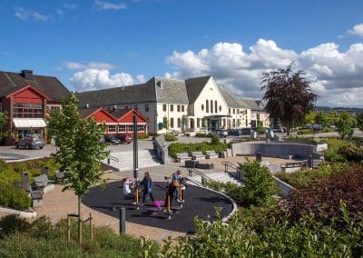Barn leker i Jernbaneparken i Verdal, shoppingsenter i bakgrunnen